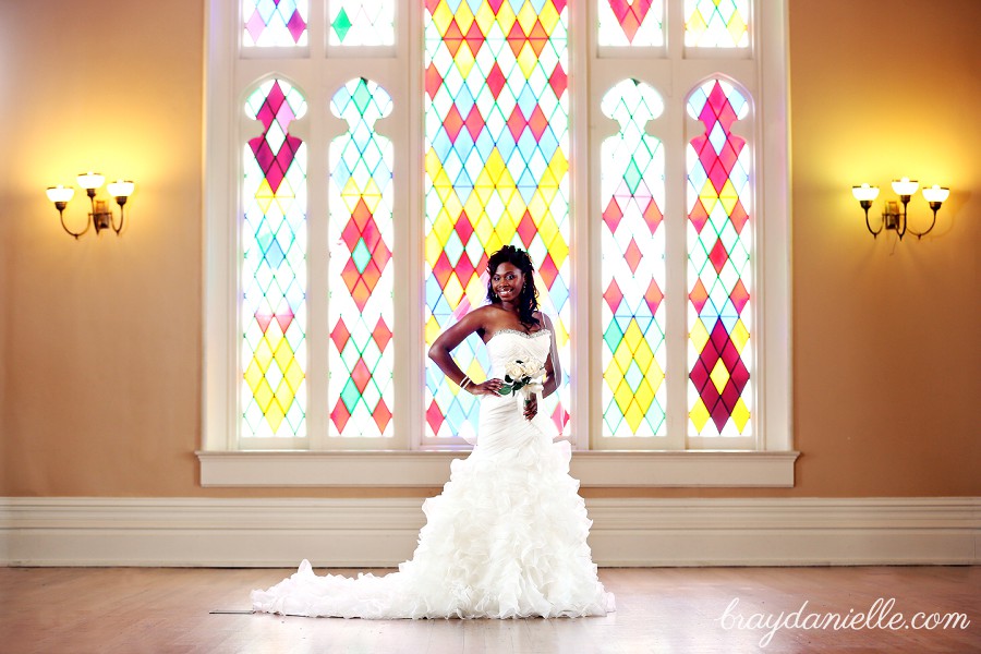 bride standing by stained glass window by Bray Danielle Photography