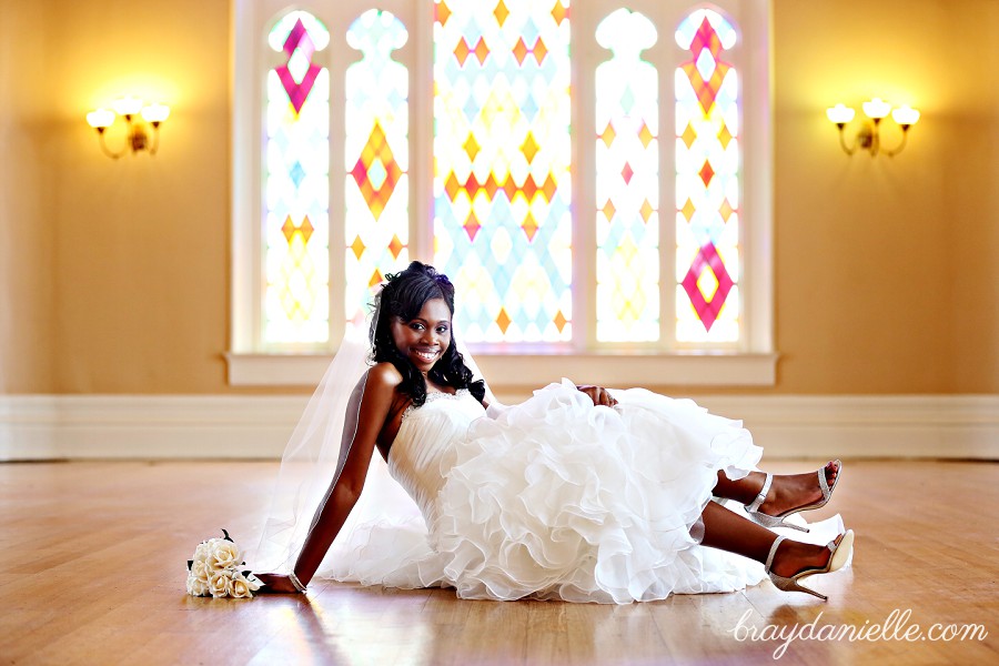 bride sitting on floor showing shoes by Bray Danielle Photography