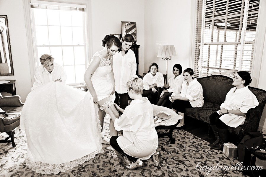 Bridesmaid helping put on garter