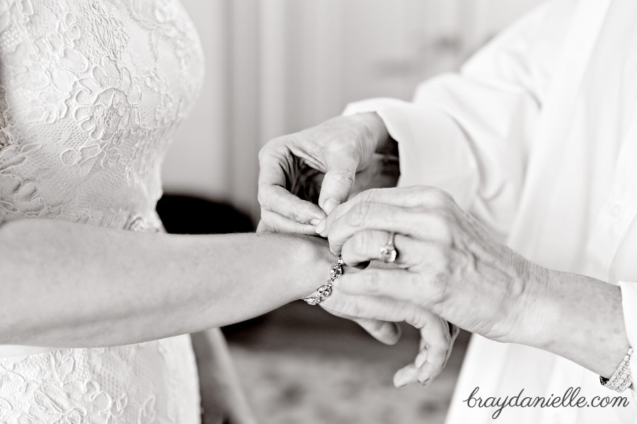 bride putting on jewelry