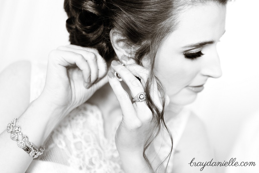 bride putting on earrings