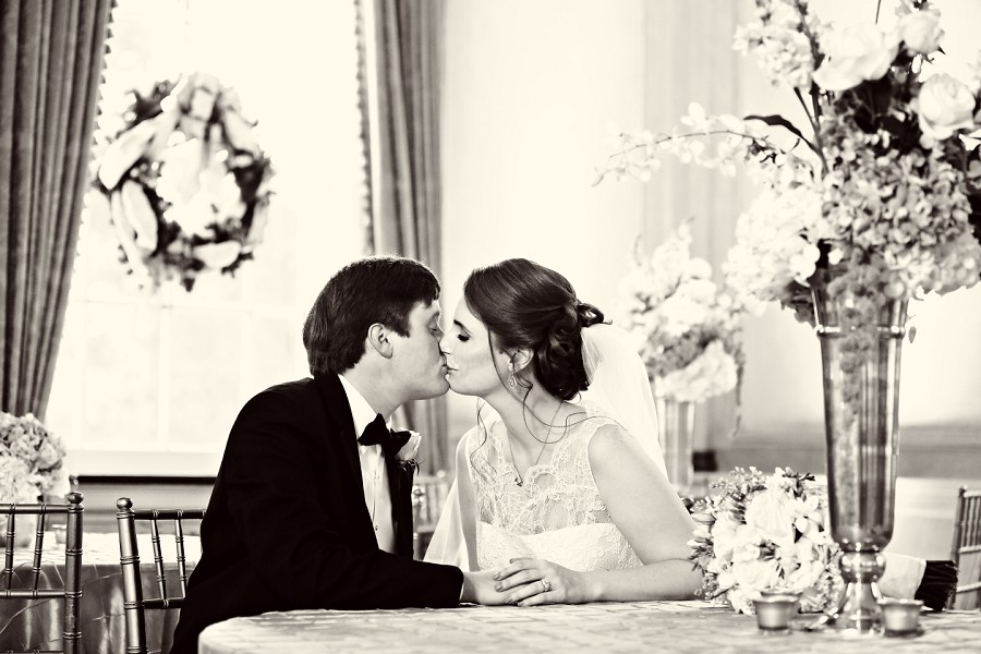 bride and groom kissing while seated