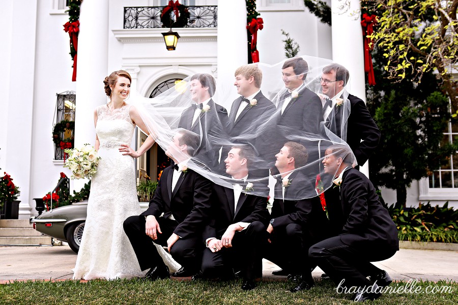 bride and groomsmen under veil