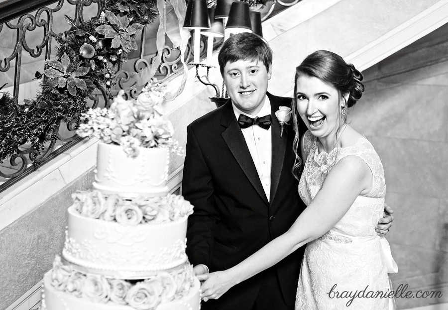 bride and groom by wedding cake