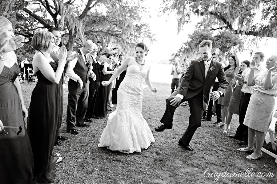 Bride and groom dancing down aisle