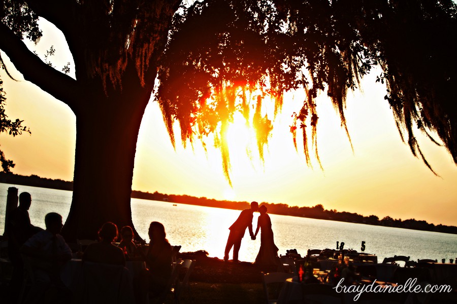 Romantic silhouette of bride and groom under an oak tree