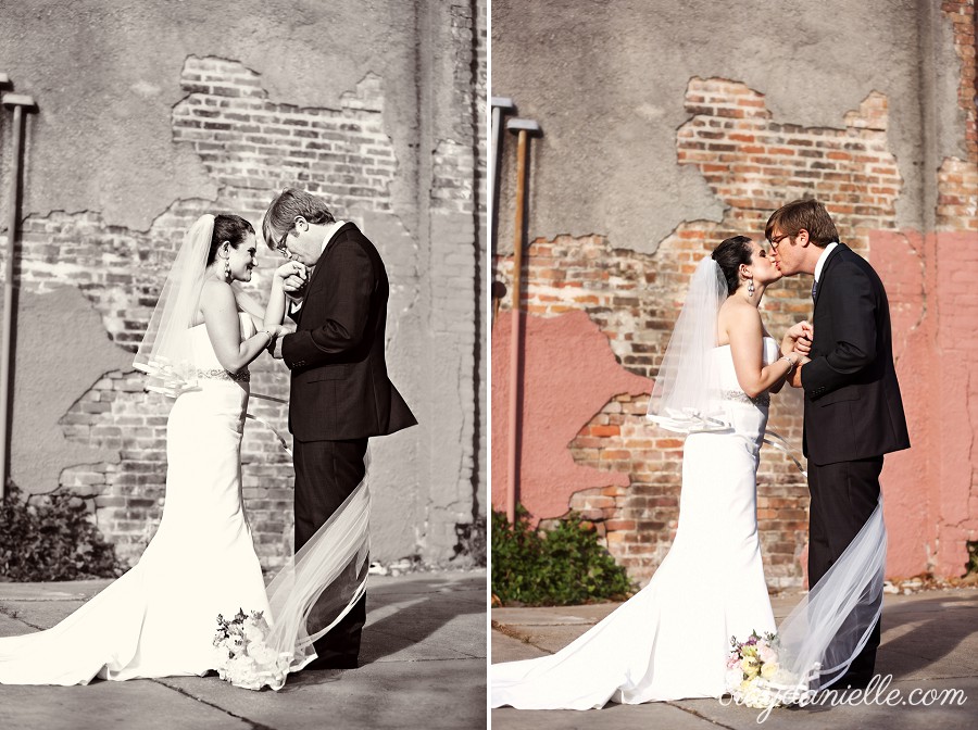 Bride and groom by brick wall