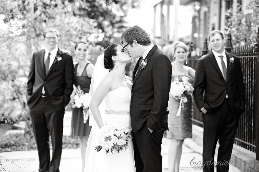 bride and groom with wedding party in background