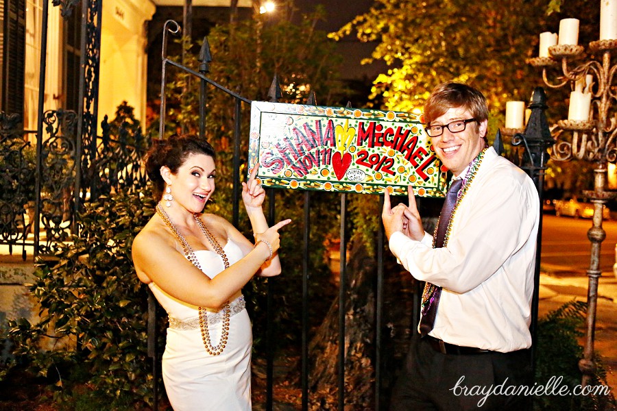 bride and groom by wedding sign