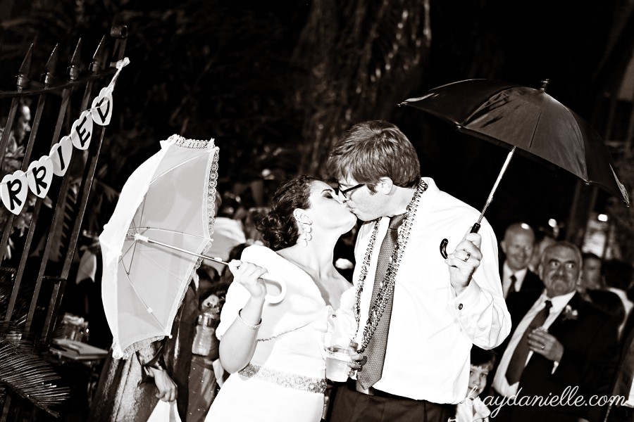 bride and groom kissing with parosels