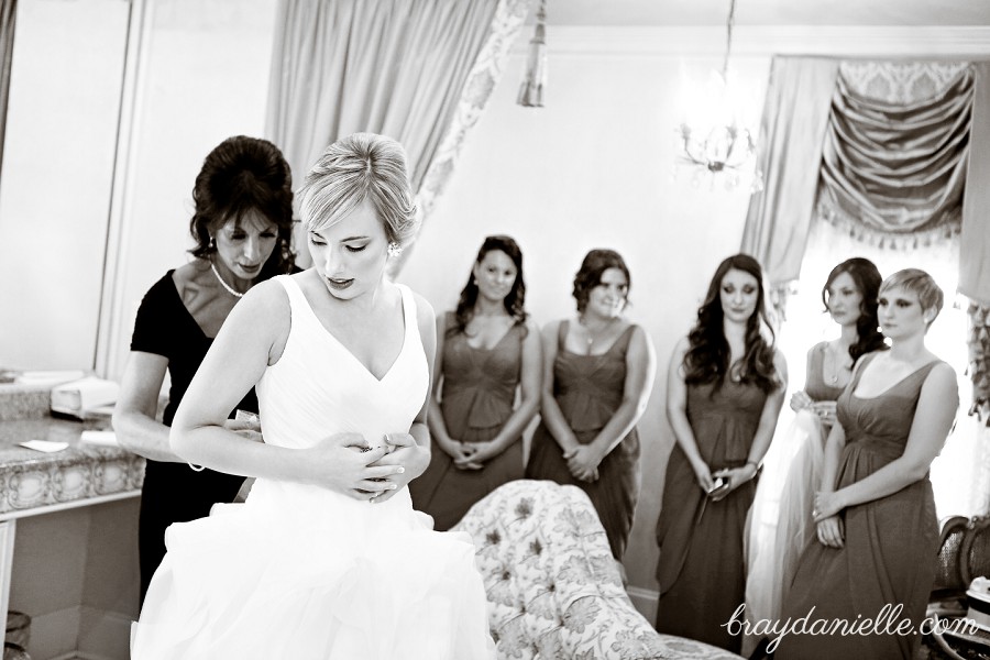 bride getting wedding dress tied