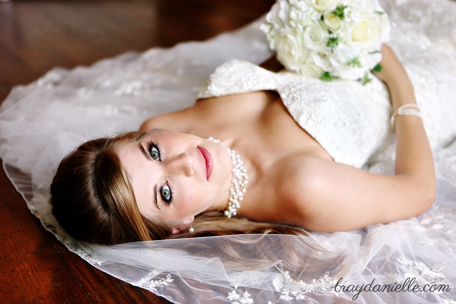 bride laying down on wooden floor bridal portrait by Bray Danielle Photography 