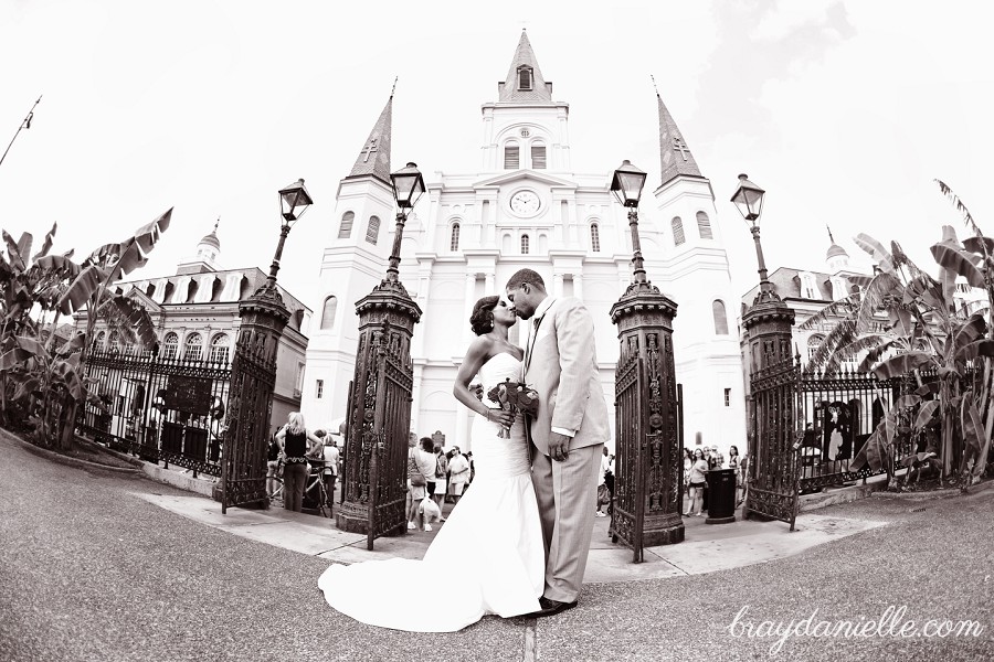 bride and groom kissing in front of cathedral