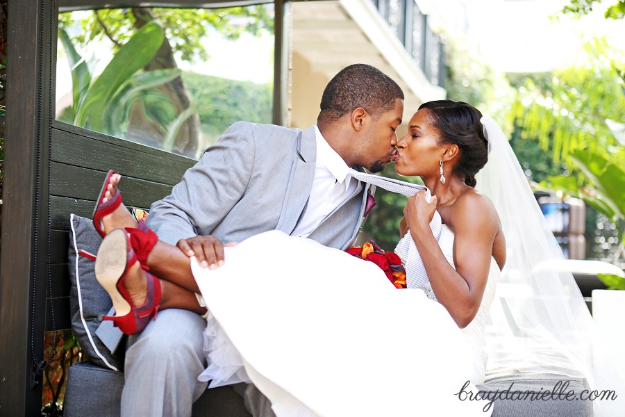 bride pulling the grooms tie while kissing