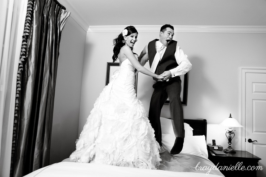 Bride and groom jumping on bed