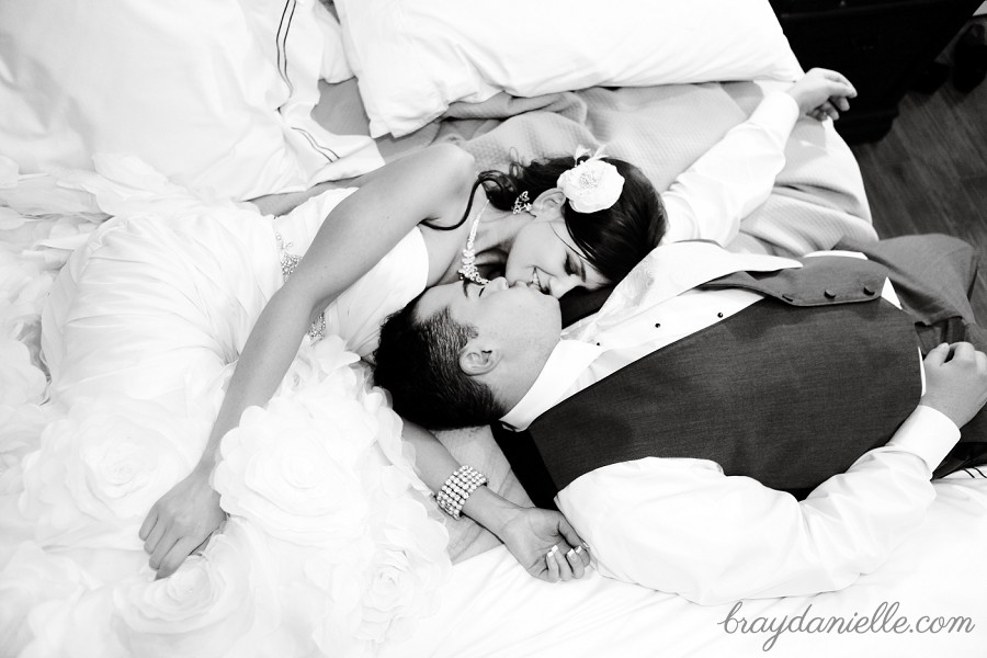 bride and groom laying on bed